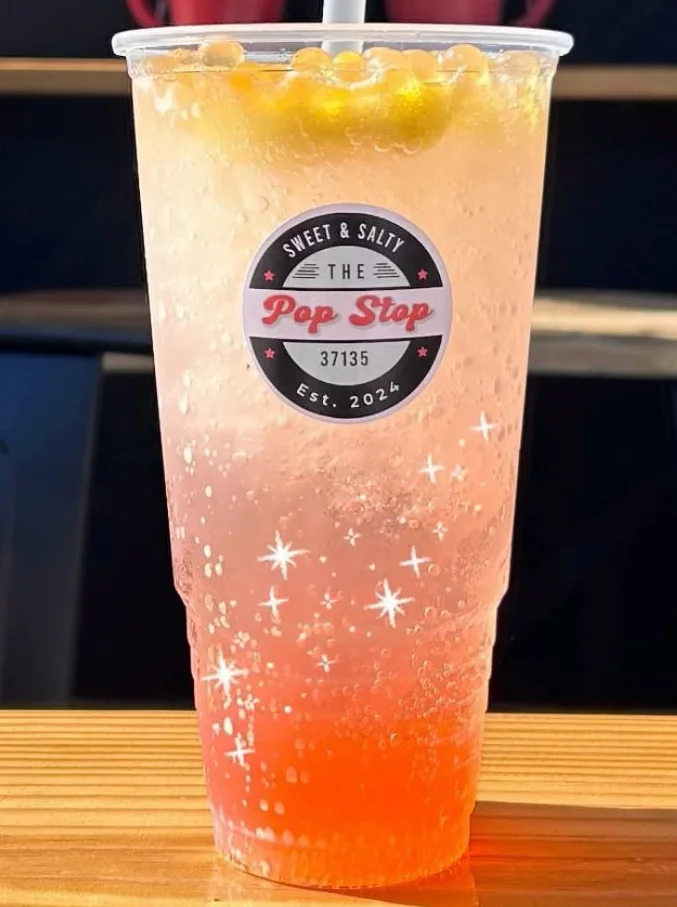 Colorful fizzy drink in a clear cup with a logo