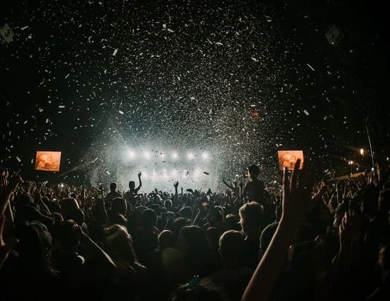 Crowd enjoying a concert with confetti falling from above