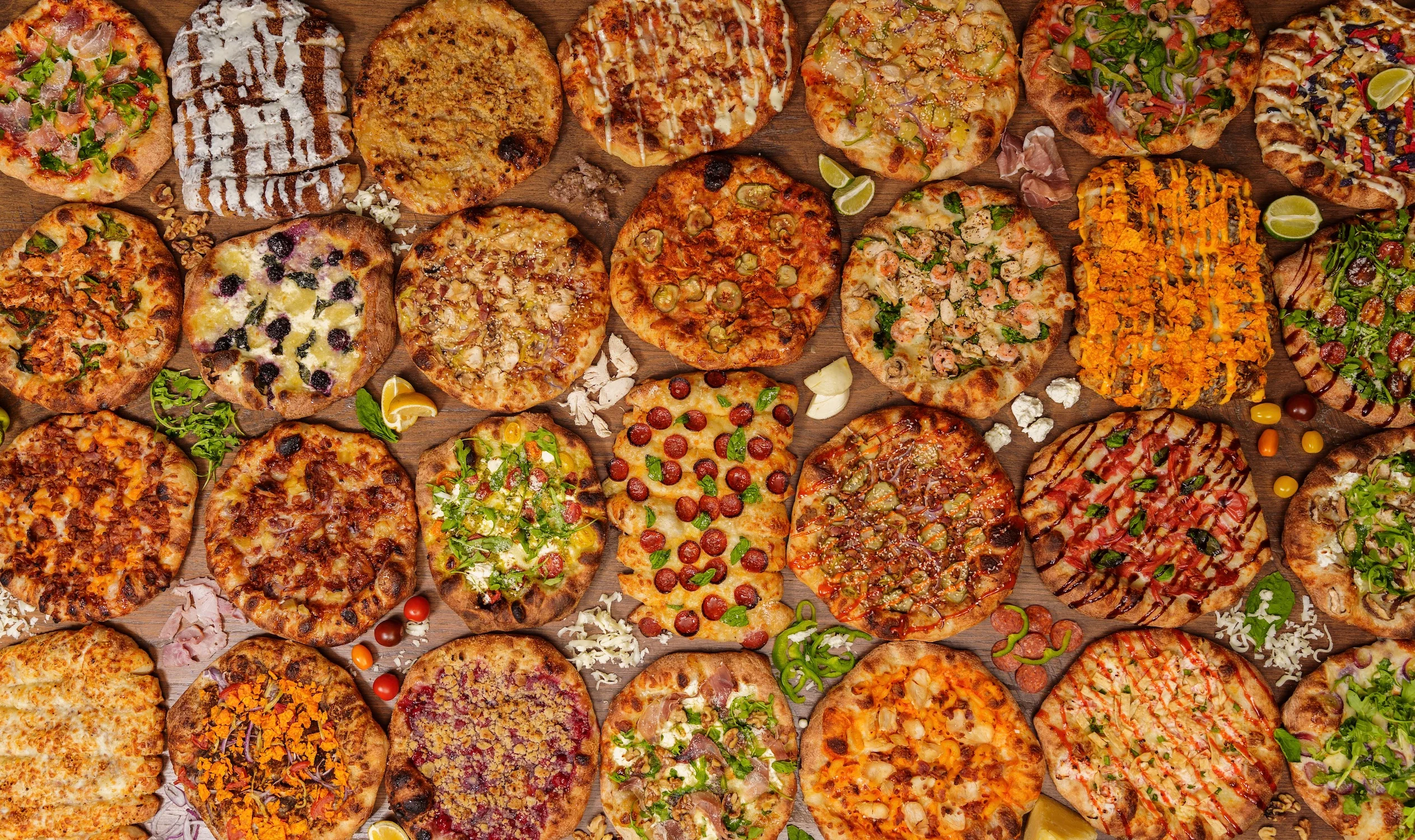 Variety of gourmet pizzas on a wooden table