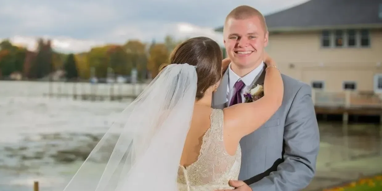 Couple embracing at a lakeside wedding ceremony