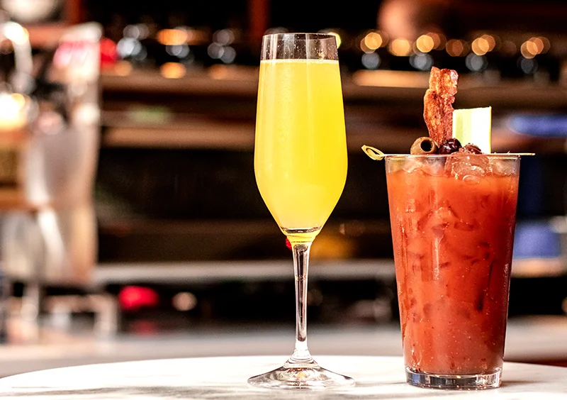 Refreshing mimosa and classic Bloody Mary cocktails on a bar counter