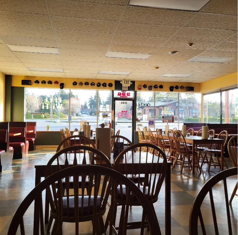 Cozy restaurant interior with wooden chairs and large windows