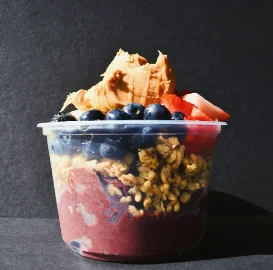 Colorful acai bowl topped with granola and peanut butter
