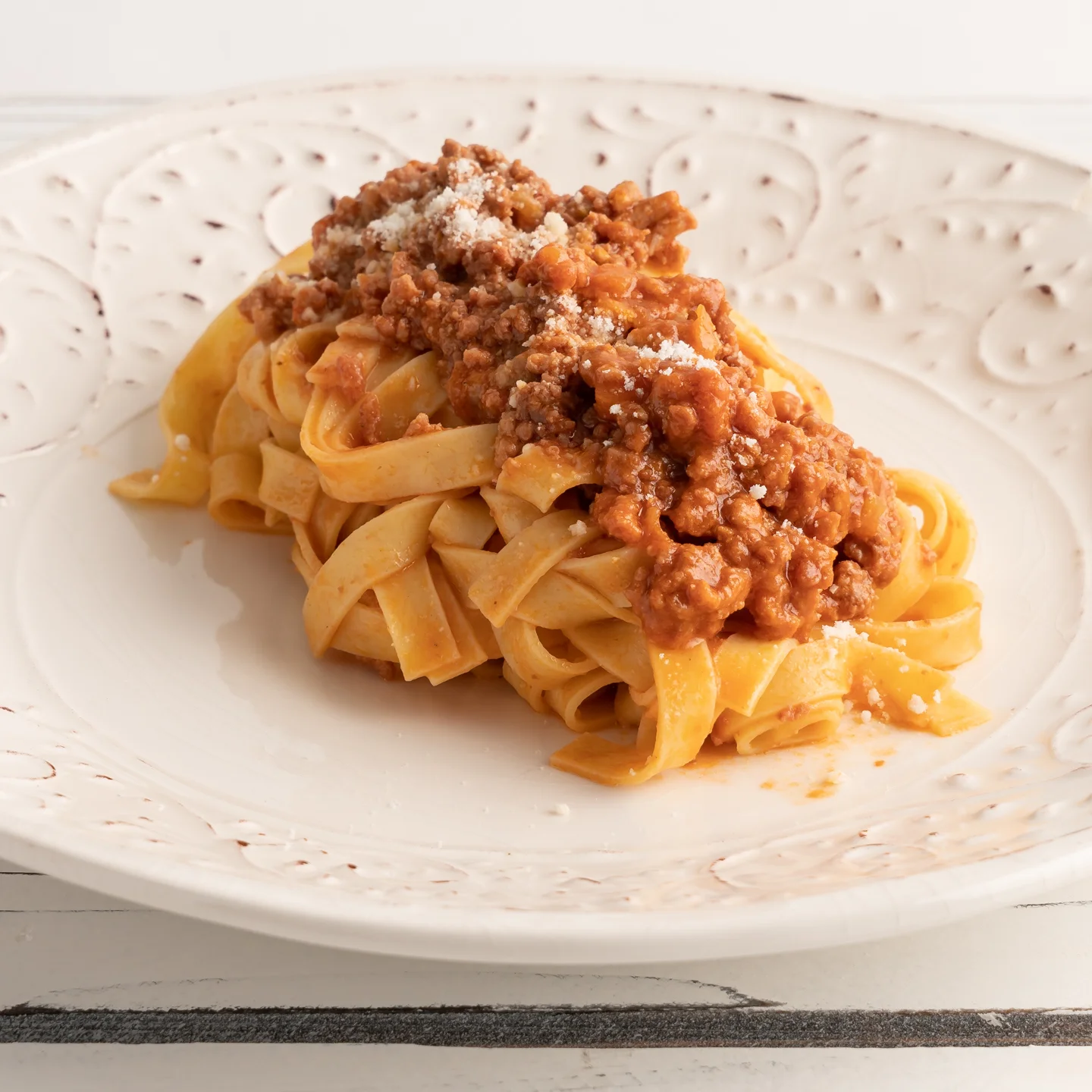 Plate of tagliatelle bolognese with parmesan cheese