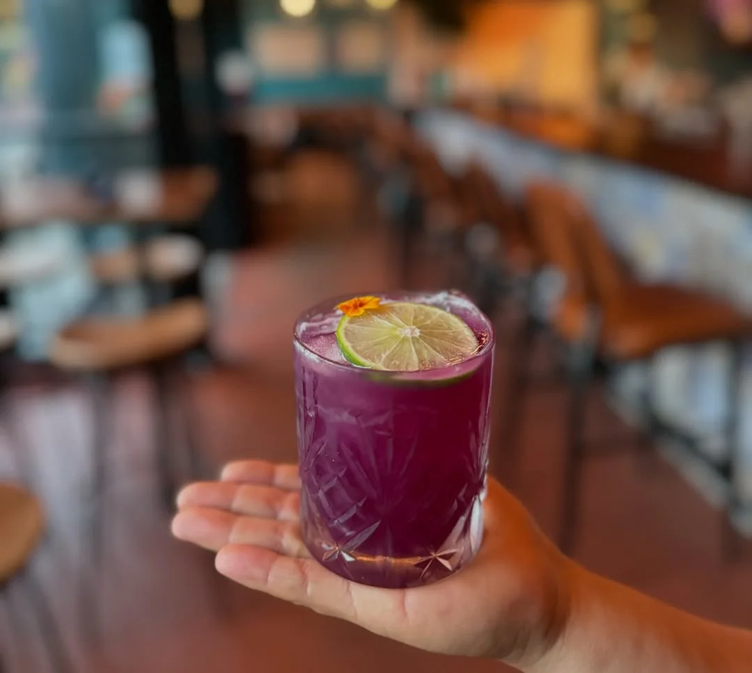 Vibrant cocktail with lime garnish in a stylish bar setting