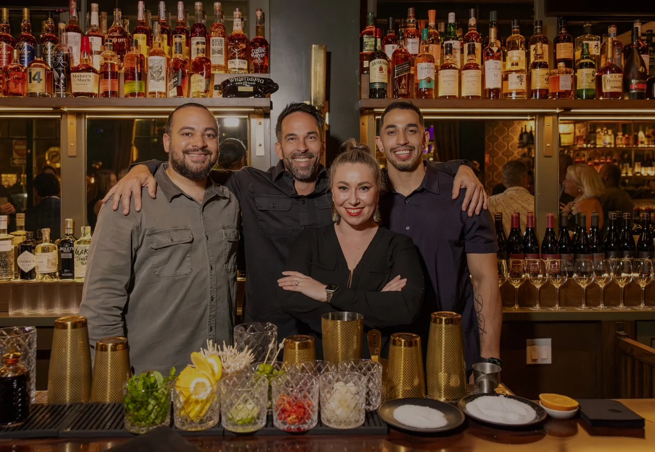 A diverse team of restaurant staff smiling together in a welcoming environment.