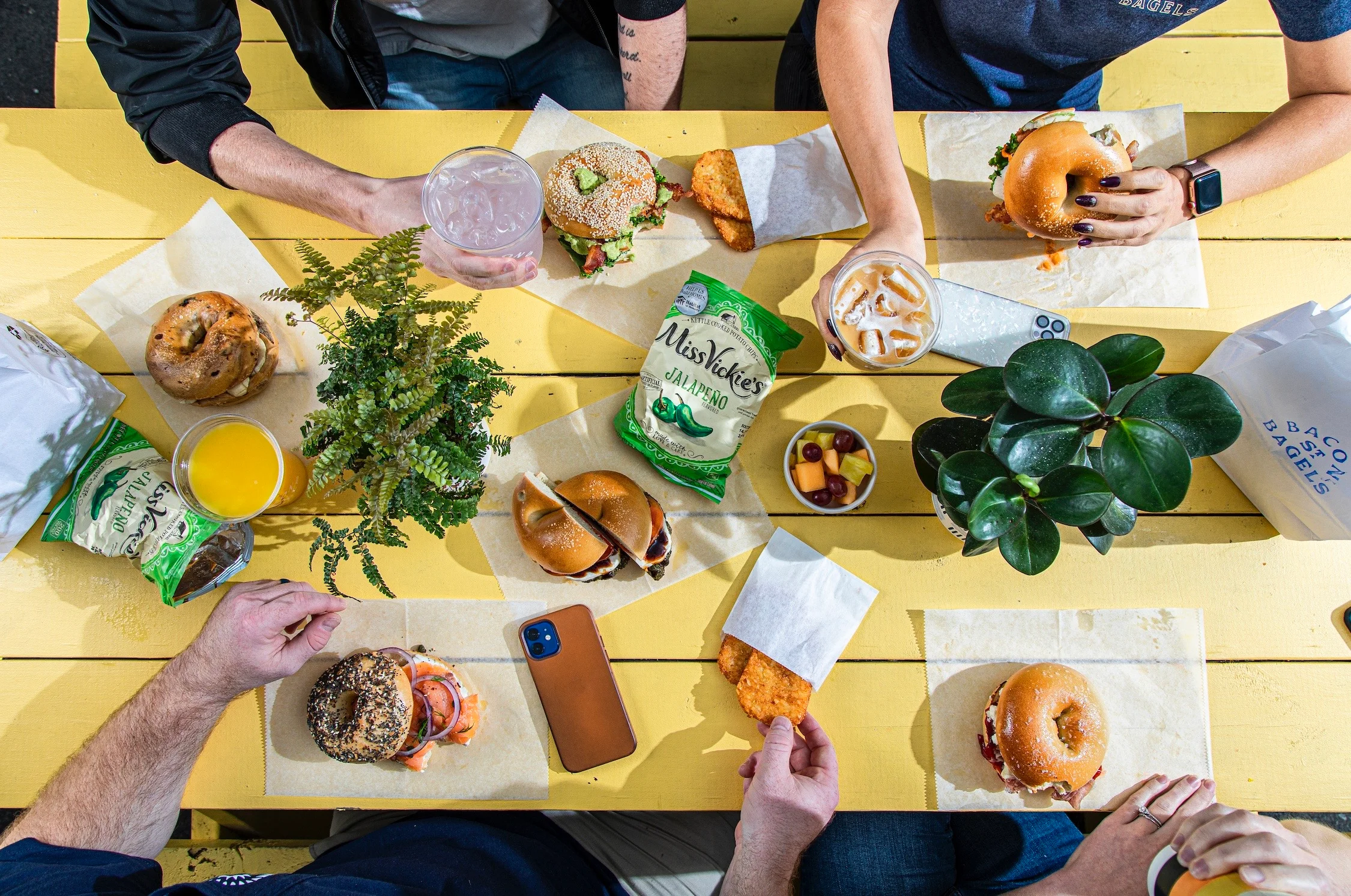 Assorted bagels and drinks on a vibrant picnic table