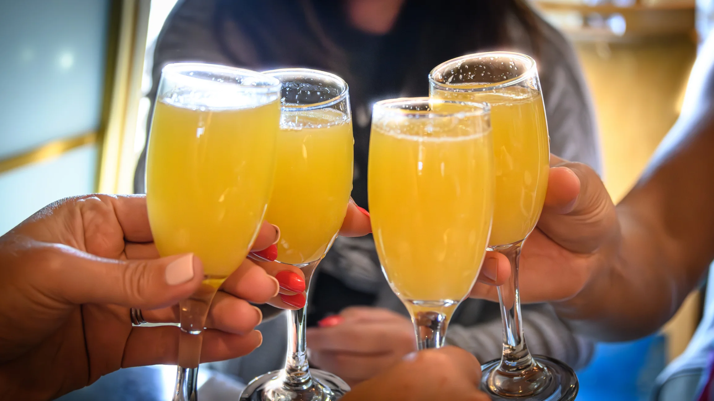 Cheers with mimosas in elegant flutes at a celebration