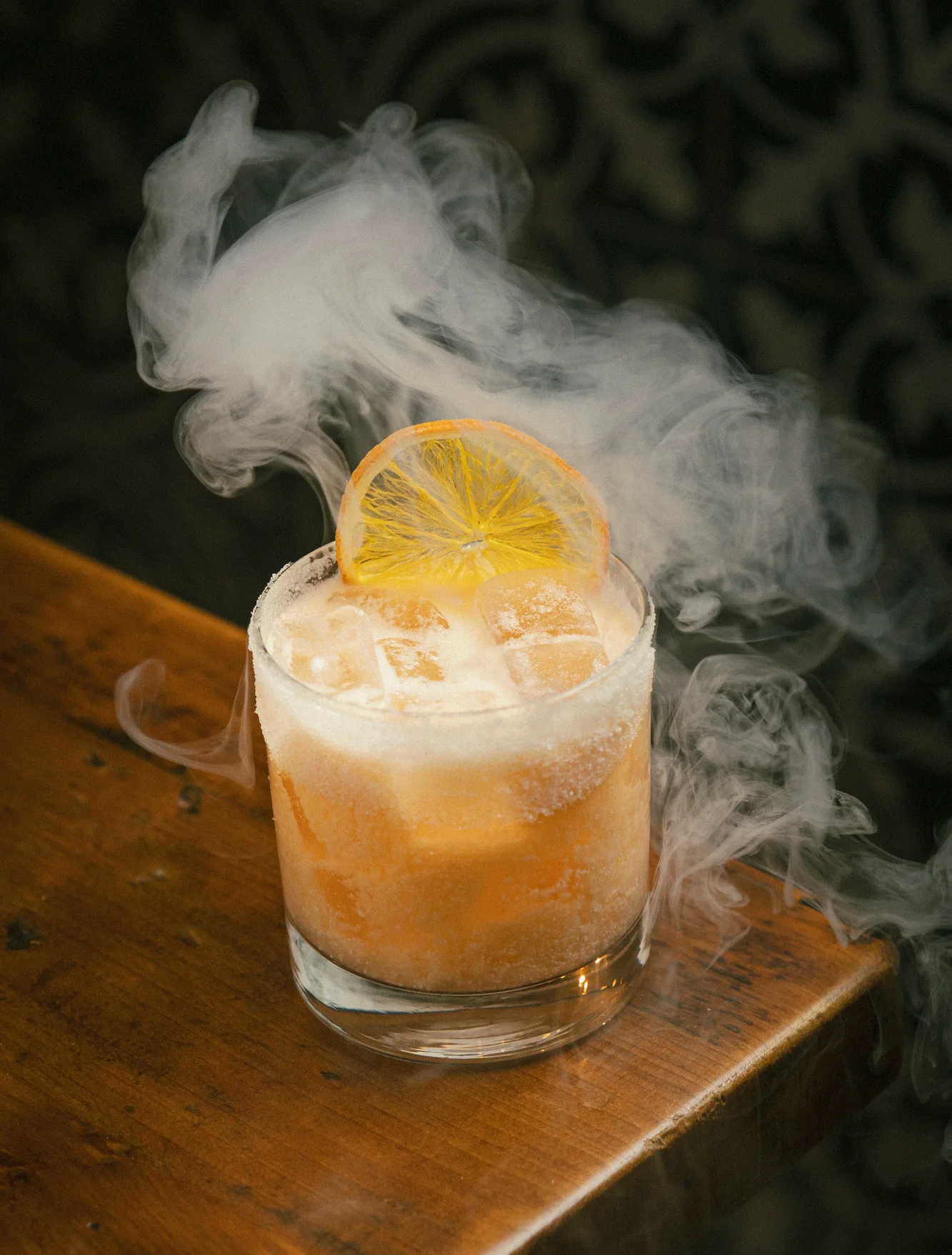 Smoky cocktail with citrus garnish in a glass