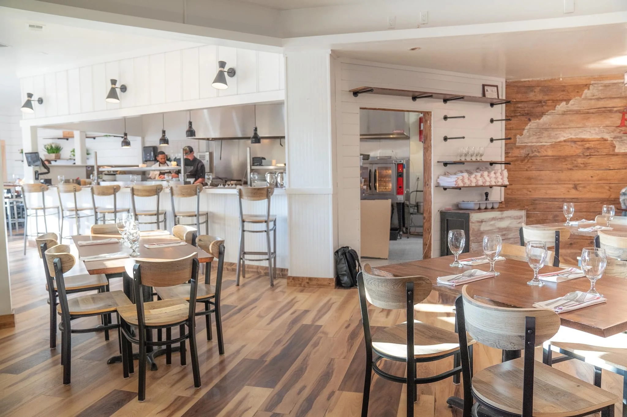 Modern restaurant interior with wooden decor and open kitchen