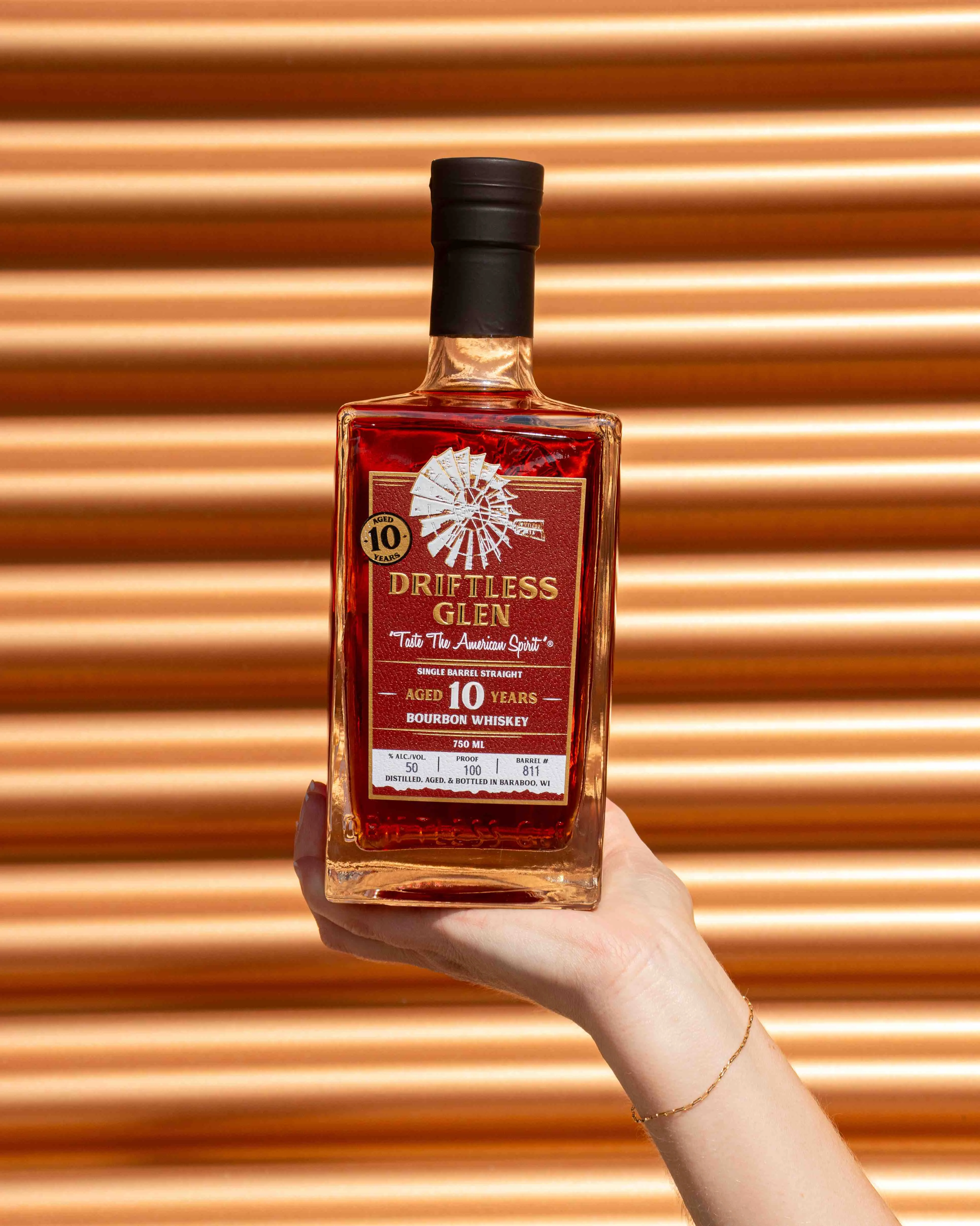 A bottle of 10-year Bourbon is held up high! 