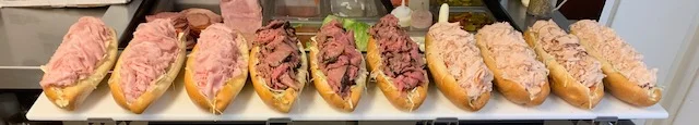 Assorted deli sandwiches with various meats on hoagie rolls
