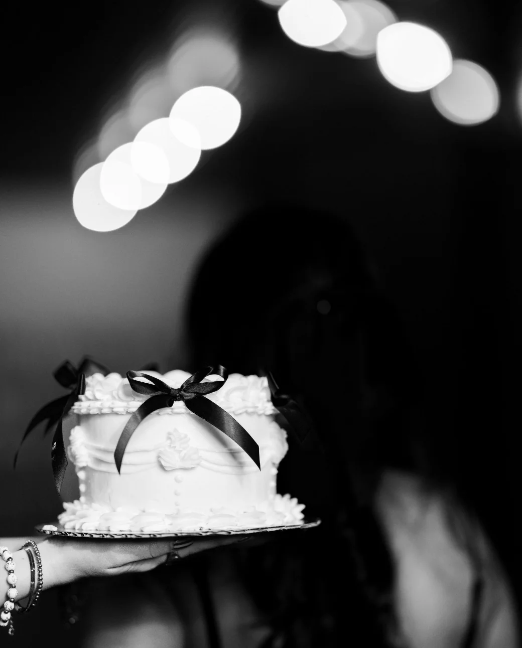 Elegant white cake with black ribbons for a celebration
