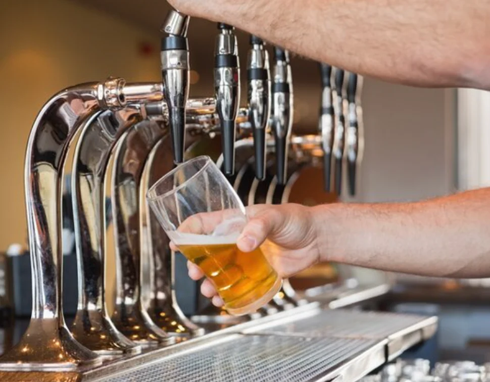 Bartender pouring a fresh draft beer at a bar