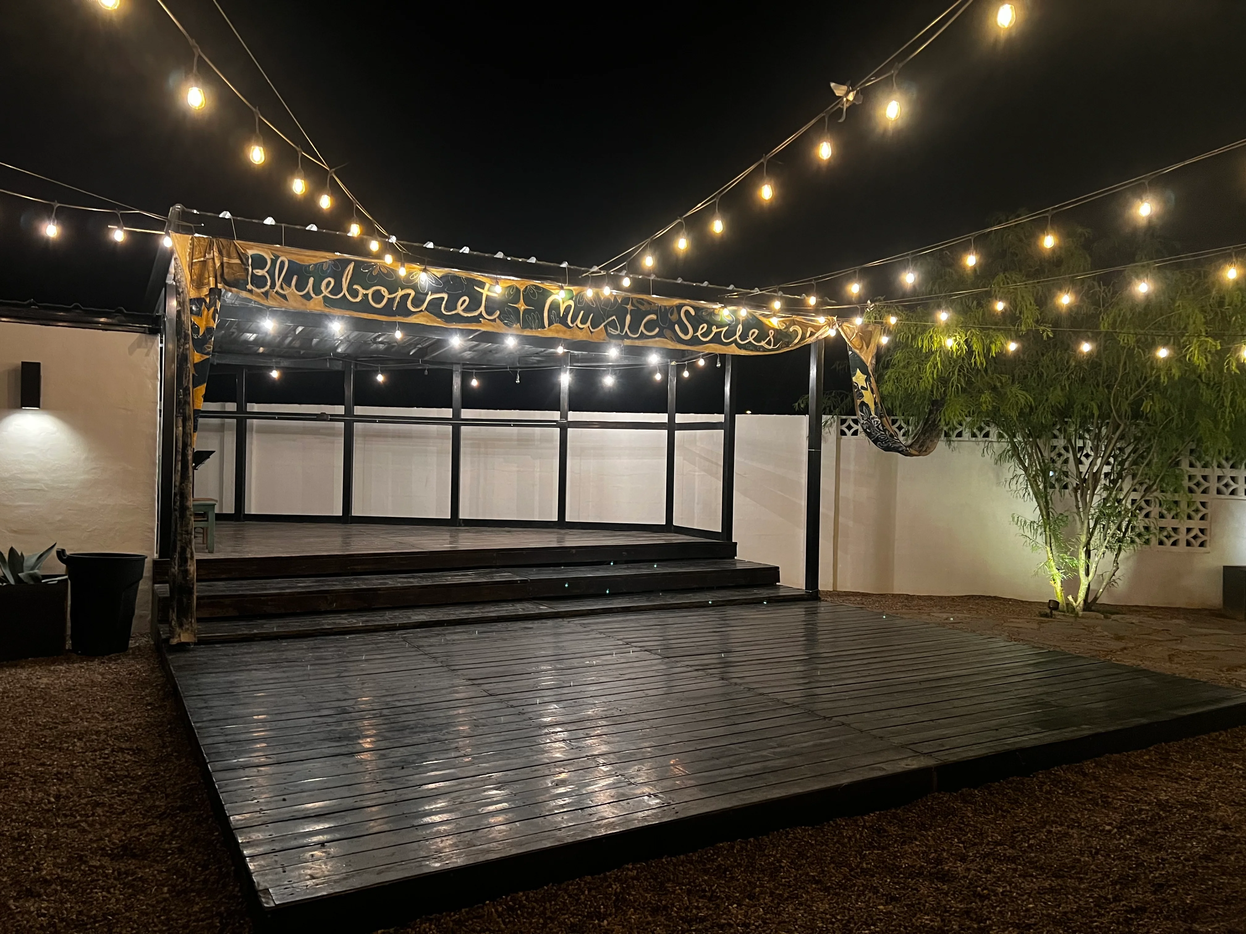 Outdoor music stage with string lights at night