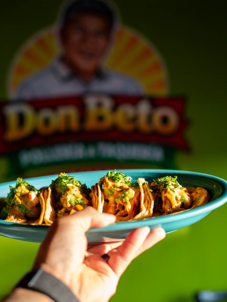 Plate of Mexican street tacos topped with fresh herbs