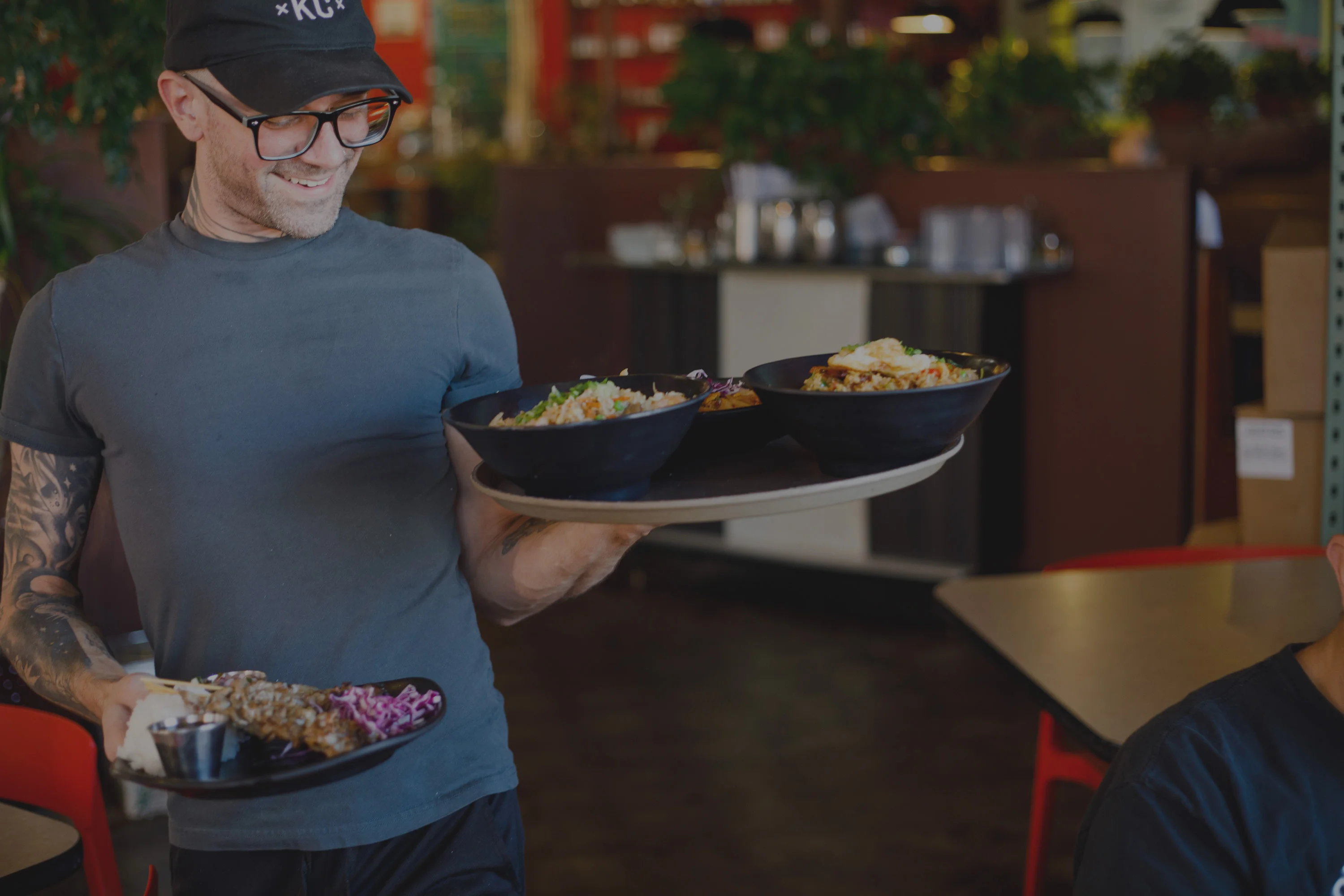 Server carrying vibrant bowls of Asian-inspired rice dishes