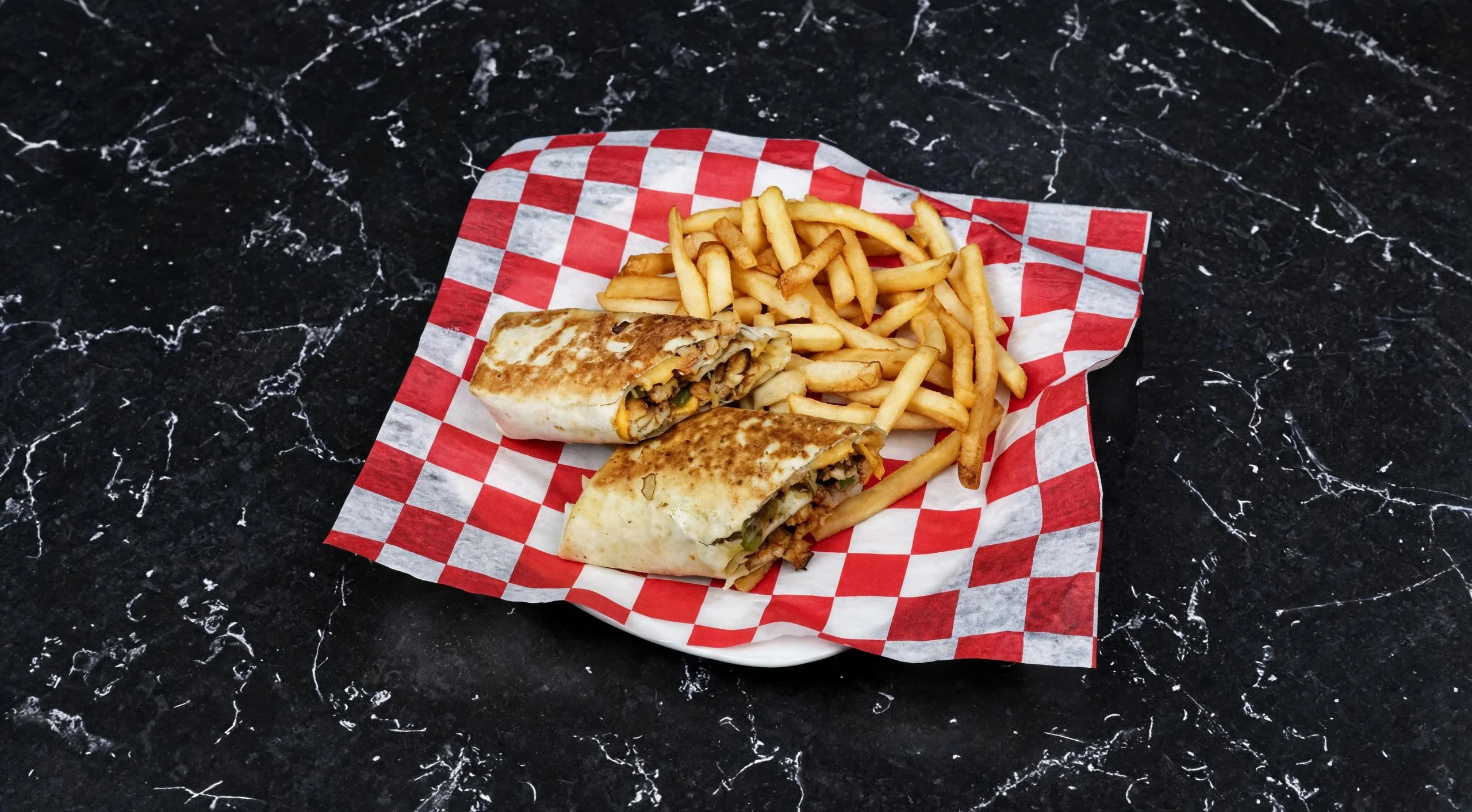 Delicious burrito platter with crispy fries on a checkered paper