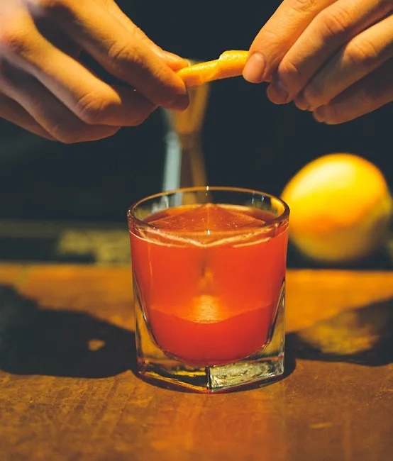 Bartender preparing a cocktail with citrus twist