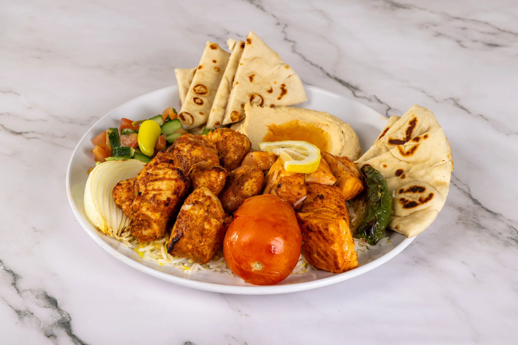 Grilled chicken kabob plate with vegetables and rice.