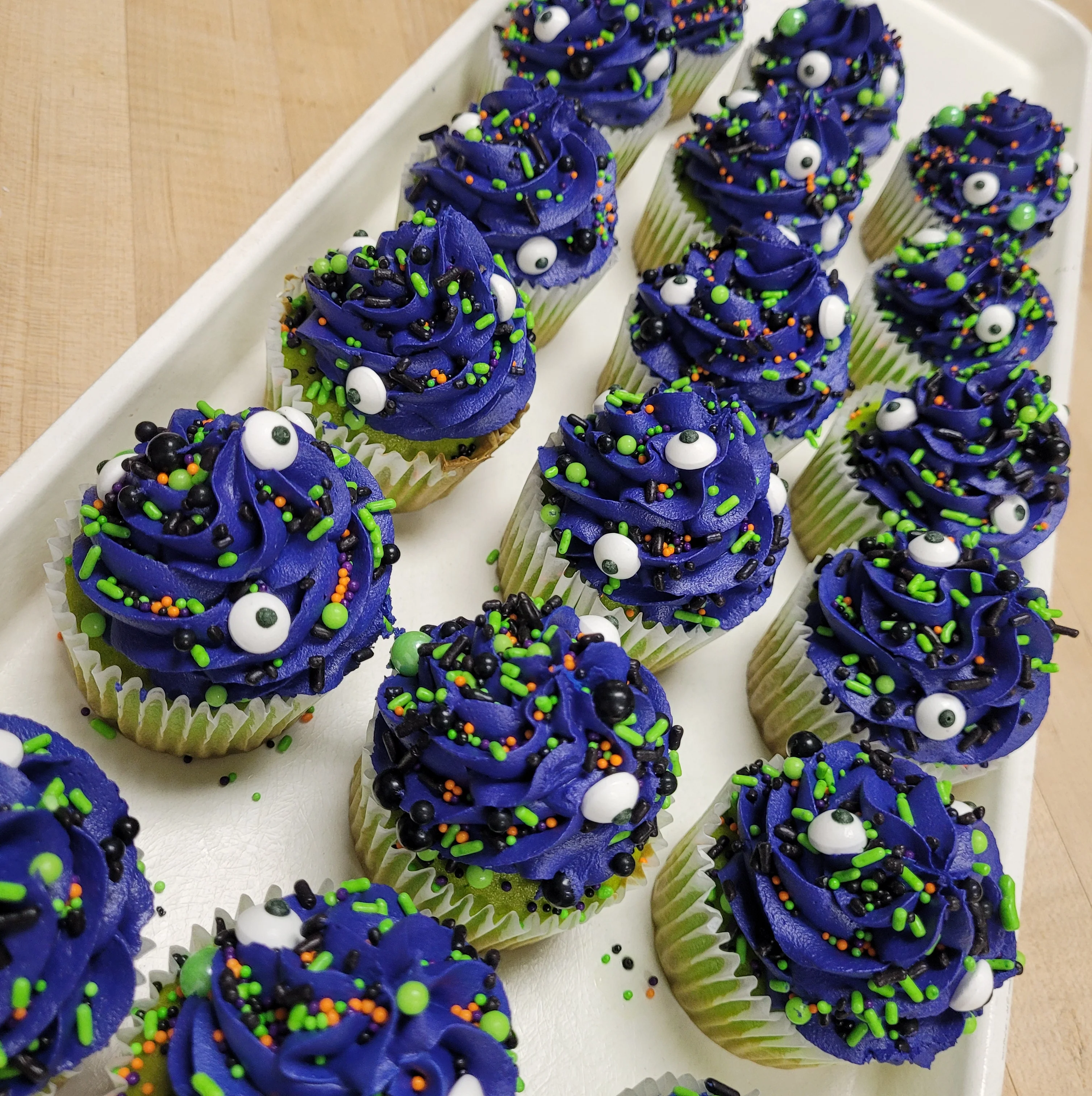 Colorful Halloween-themed cupcakes with purple frosting and candy eyes