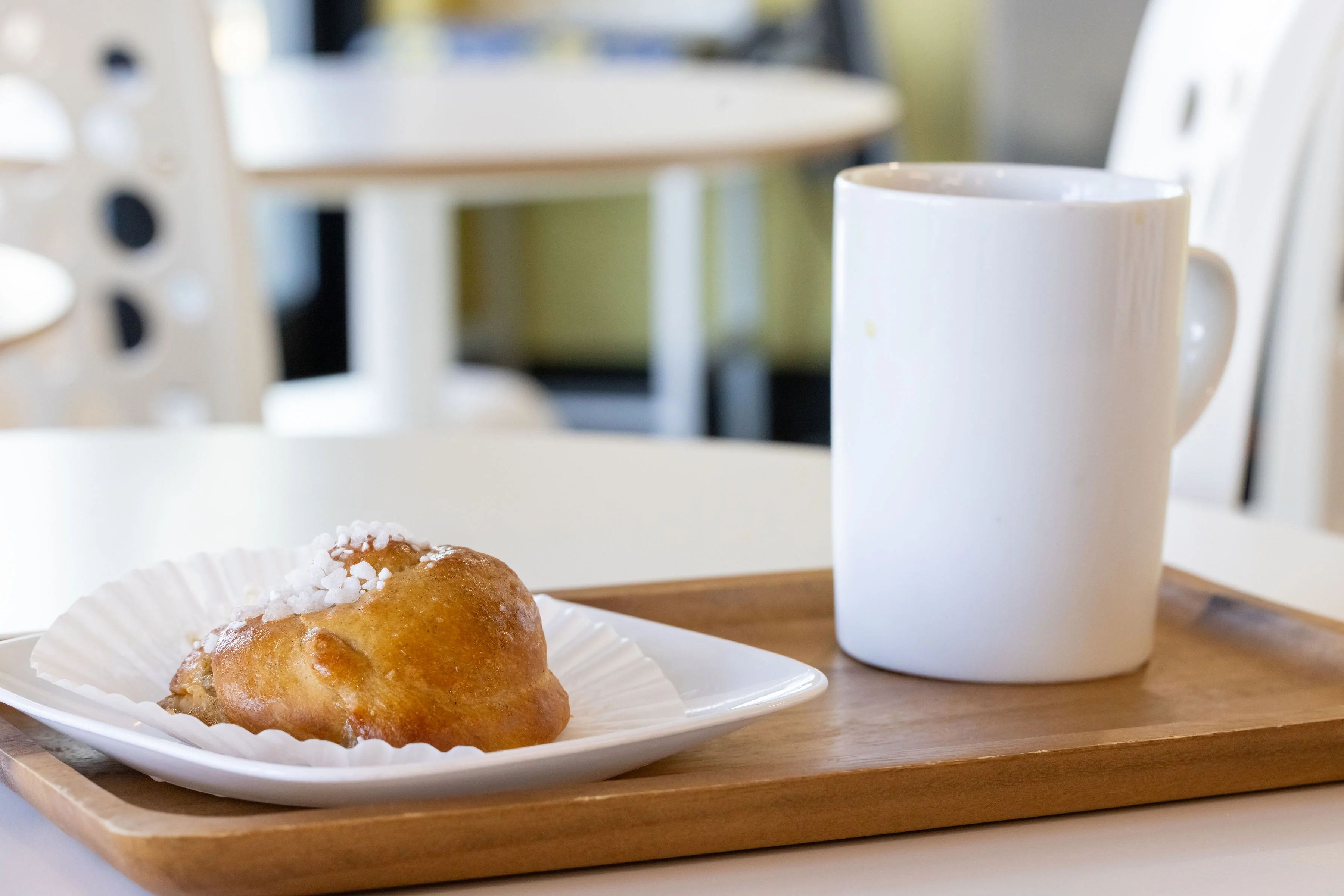 Swedish kanelbullar with coffee on a wooden tray