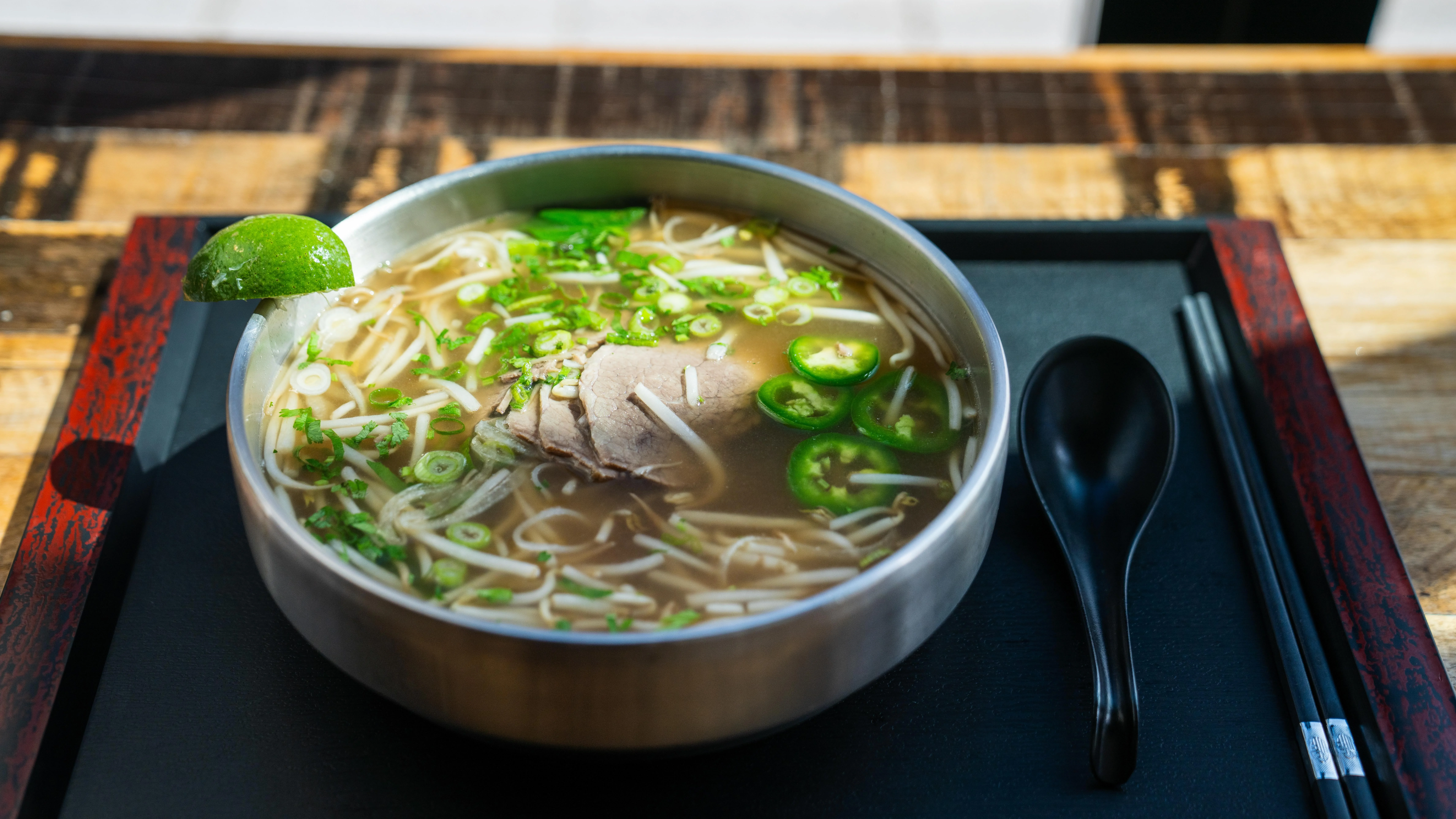 Bowl of Vietnamese pho with beef and fresh herbs