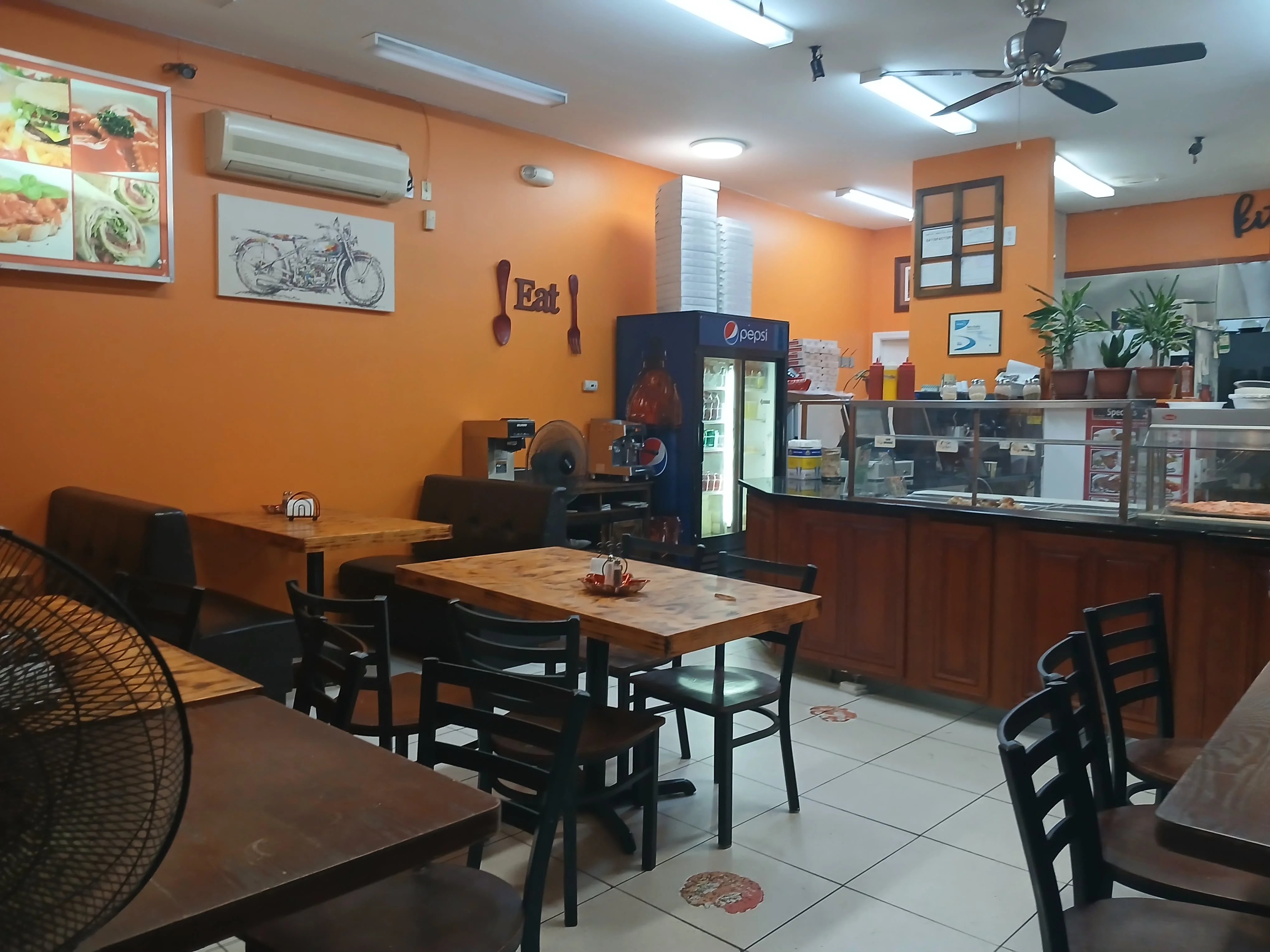 Cozy restaurant interior with wooden tables and orange walls