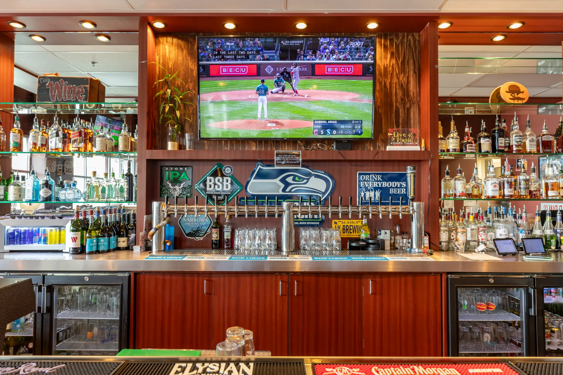 Modern bar with a variety of spirits and a sports screen