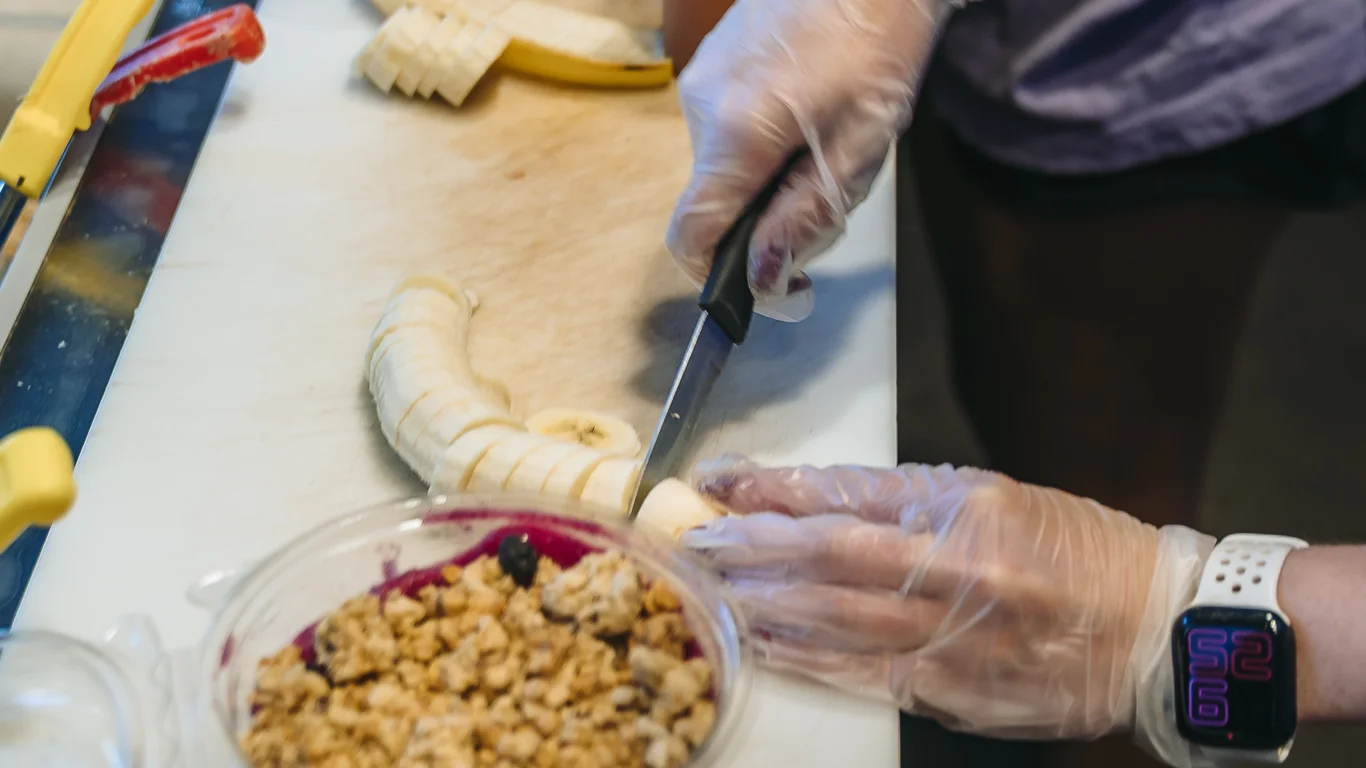 Preparing acai bowls with fresh fruit and granola
