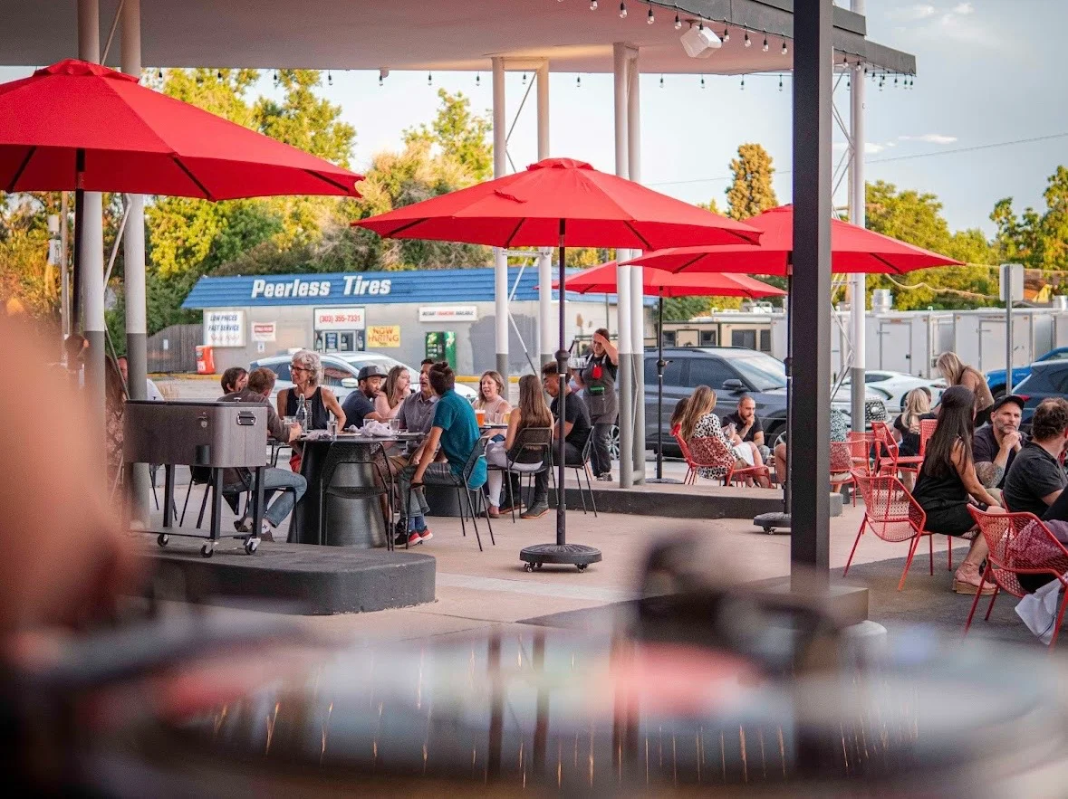 Outdoor dining area with red umbrellas and lively atmosphere