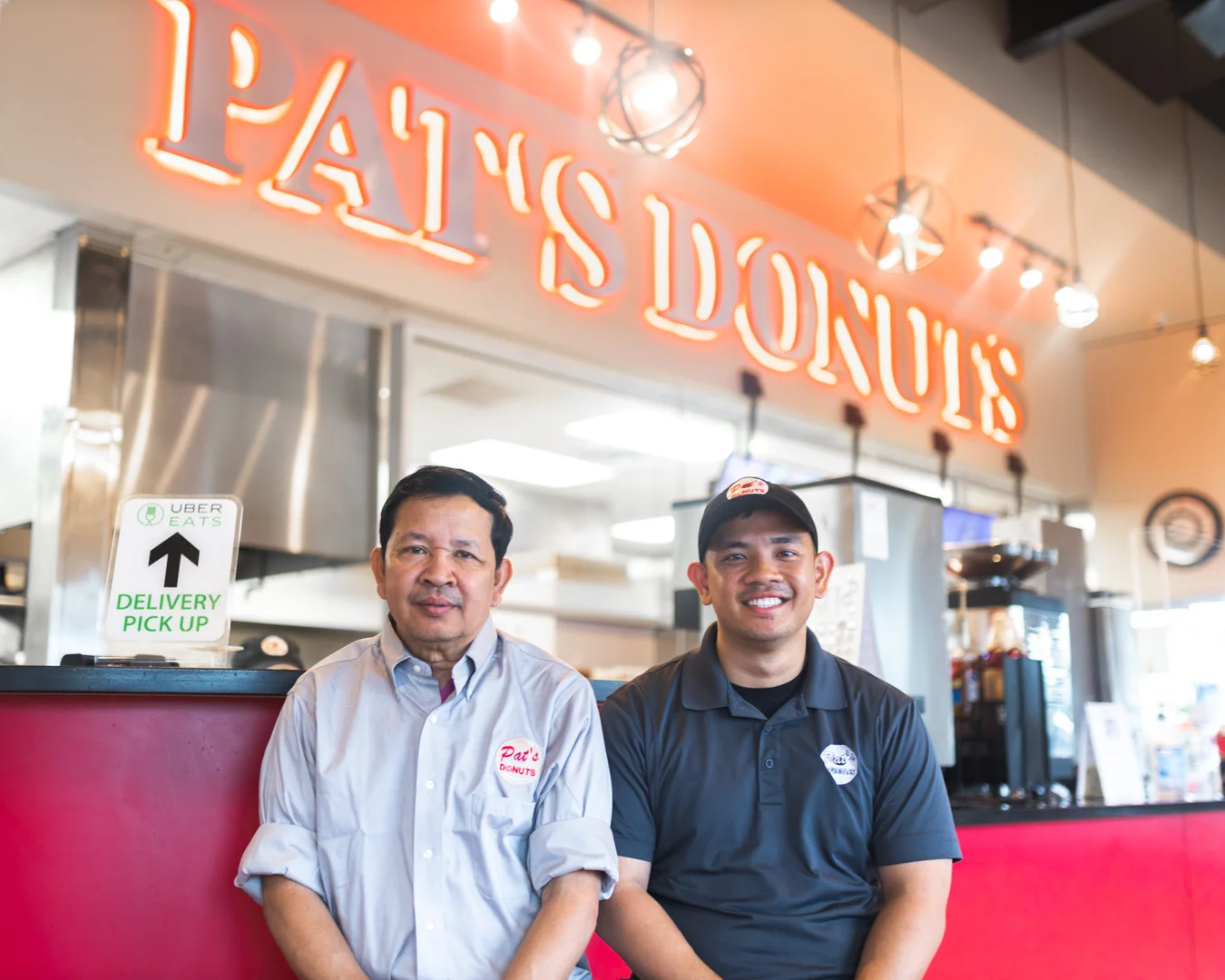 Cozy donut shop interior with staff and bright signage