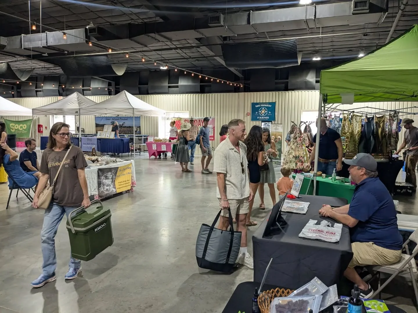 Indoor market with vendors and shoppers exploring various stalls