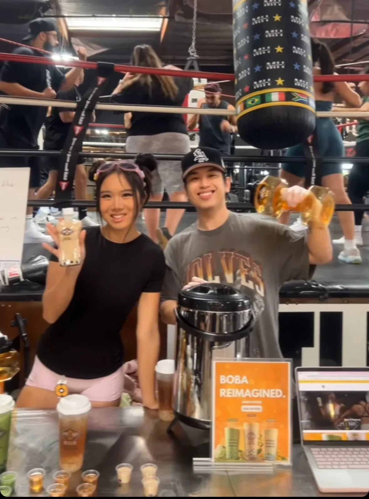 Two young adults promoting boba drinks at a fitness event
