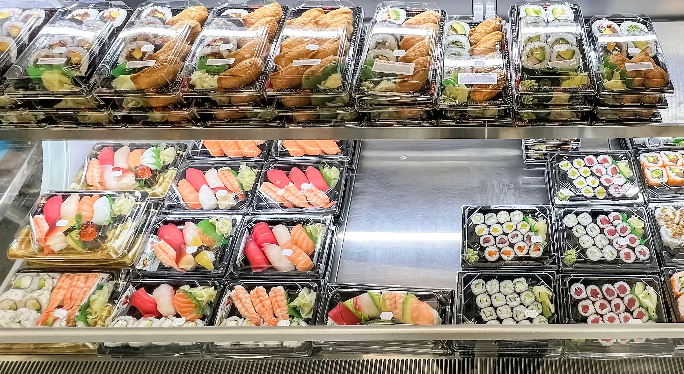 Assorted sushi platters in a display case