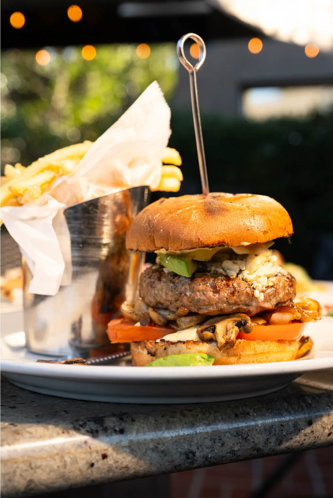 Juicy gourmet burger with fries served outdoors