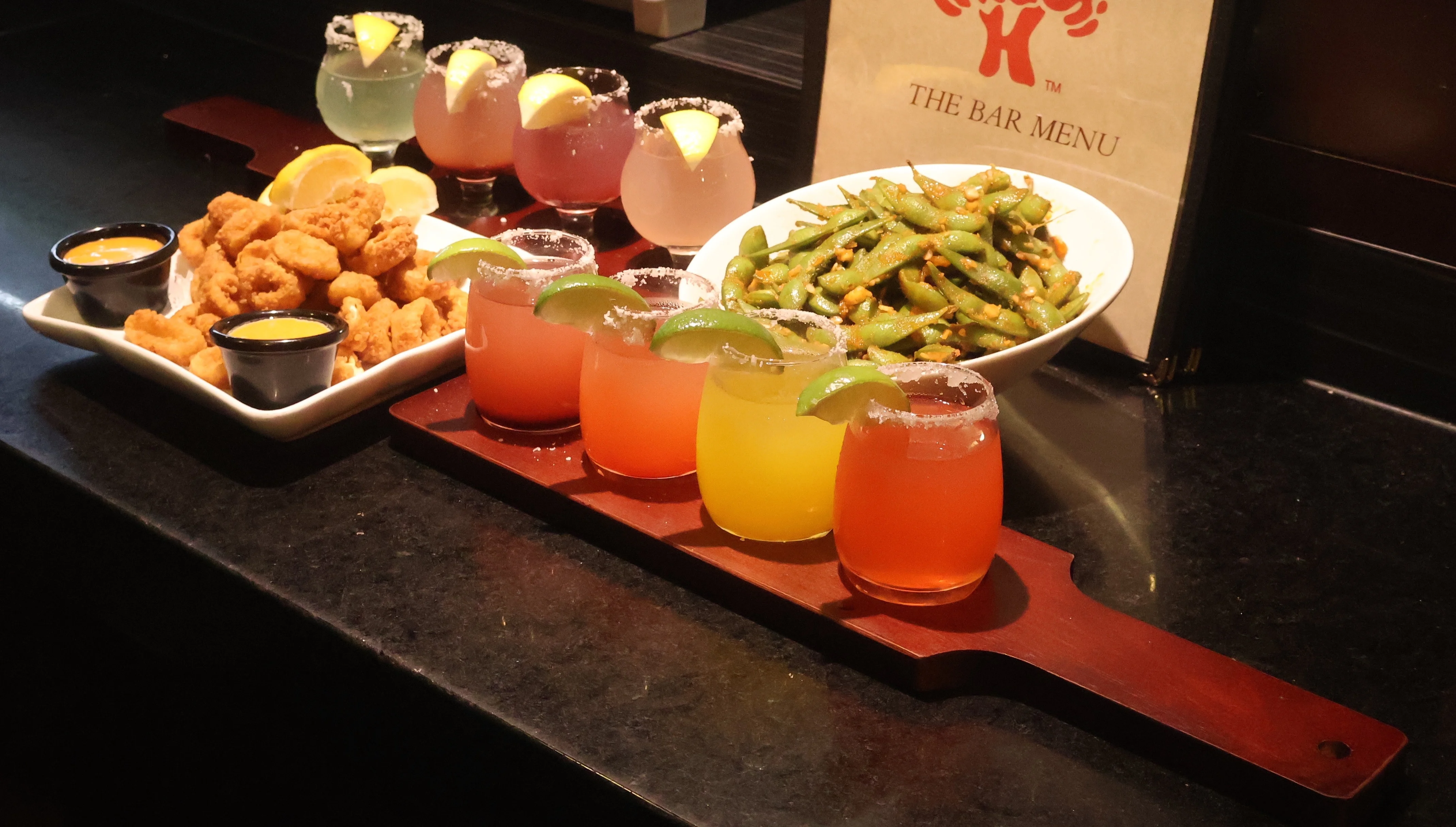 Colorful cocktails and crispy fried shrimp in a vibrant bar setting
