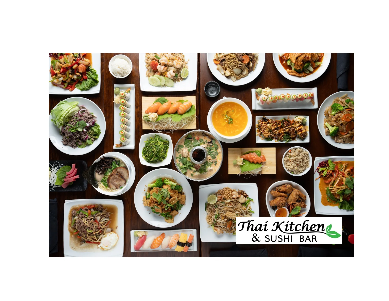 A variety of Thai and sushi dishes beautifully arranged on a wooden table, showcasing colorful and diverse meals.