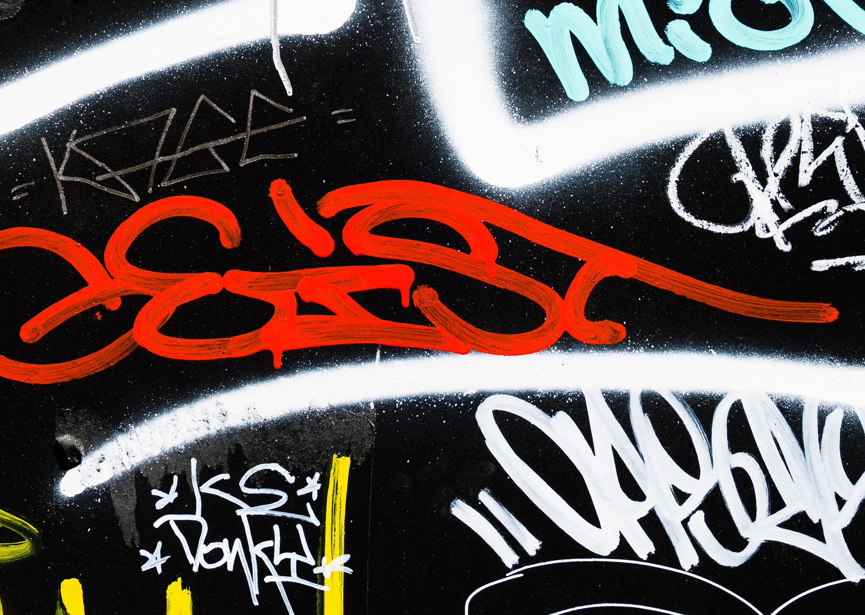 Colorful urban graffiti art on a black wall