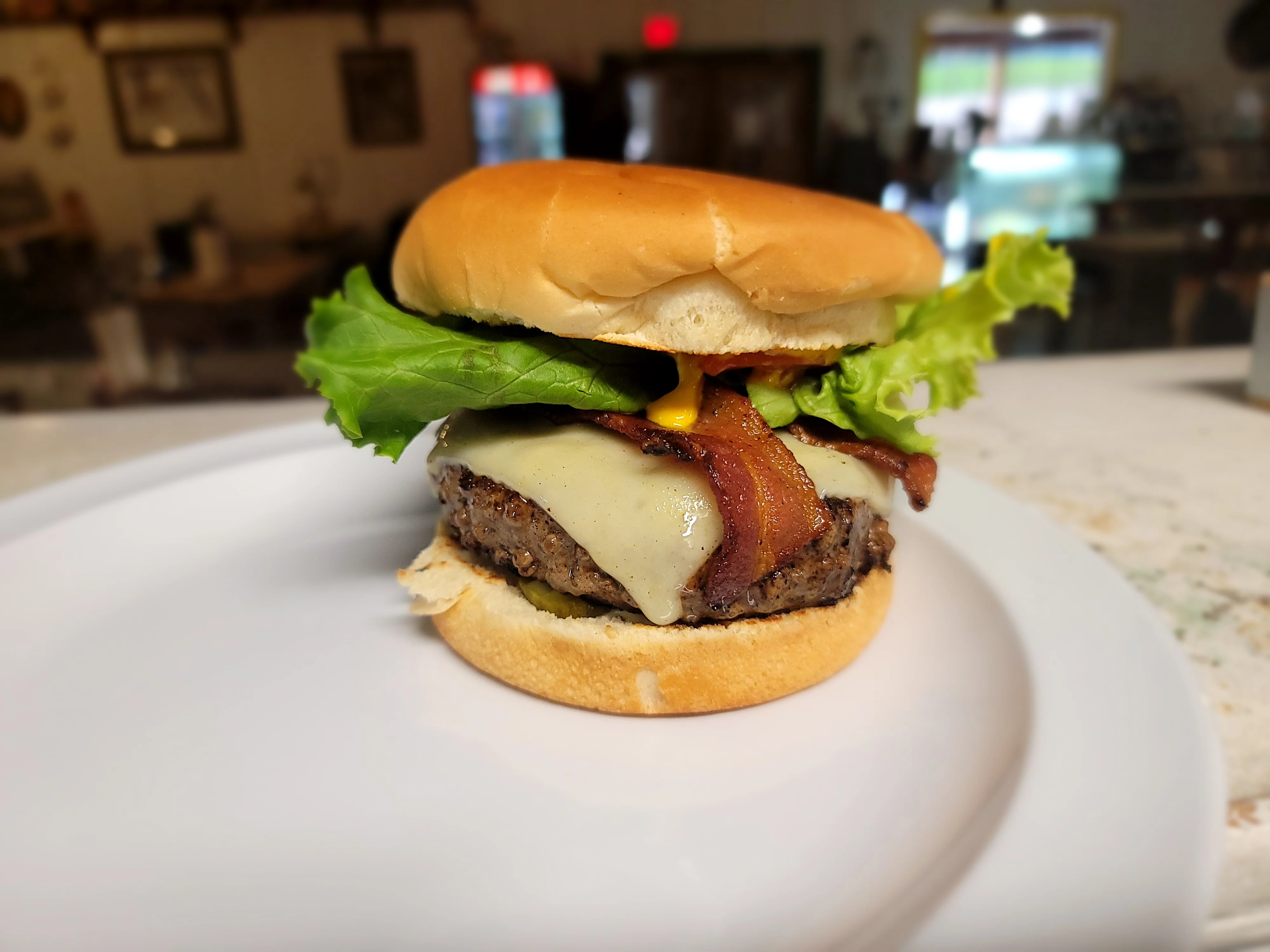 Juicy cheeseburger with bacon and lettuce on a toasted bun