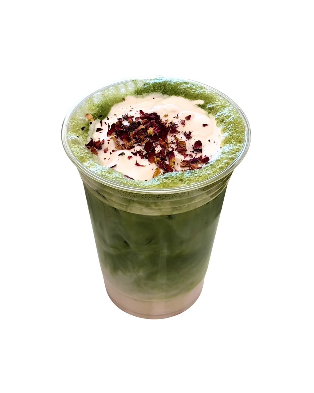 A vibrant green drink in a clear cup, topped with cream and dried rose petals, showcasing layers of green tea.