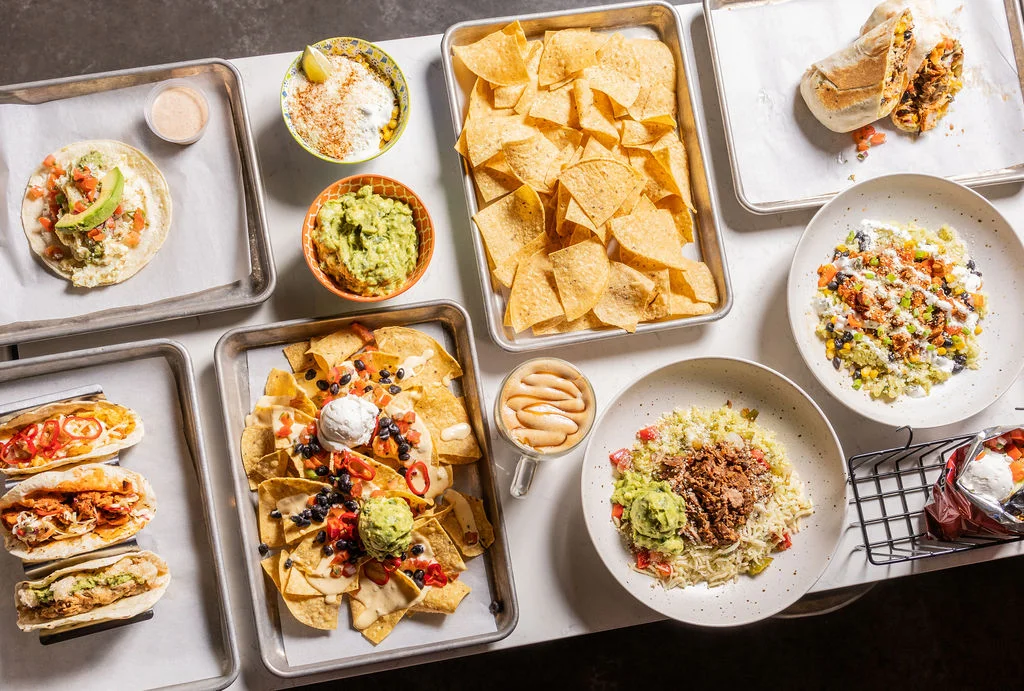 Colorful Mexican feast with tacos, nachos, and guacamole