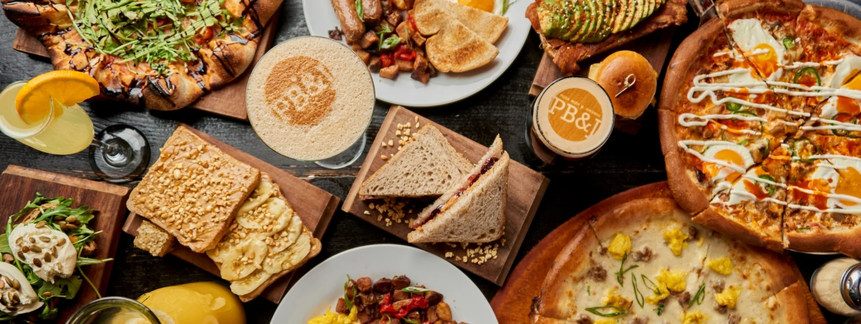 Variety of gourmet pizzas and sandwiches in a vibrant restaurant setting