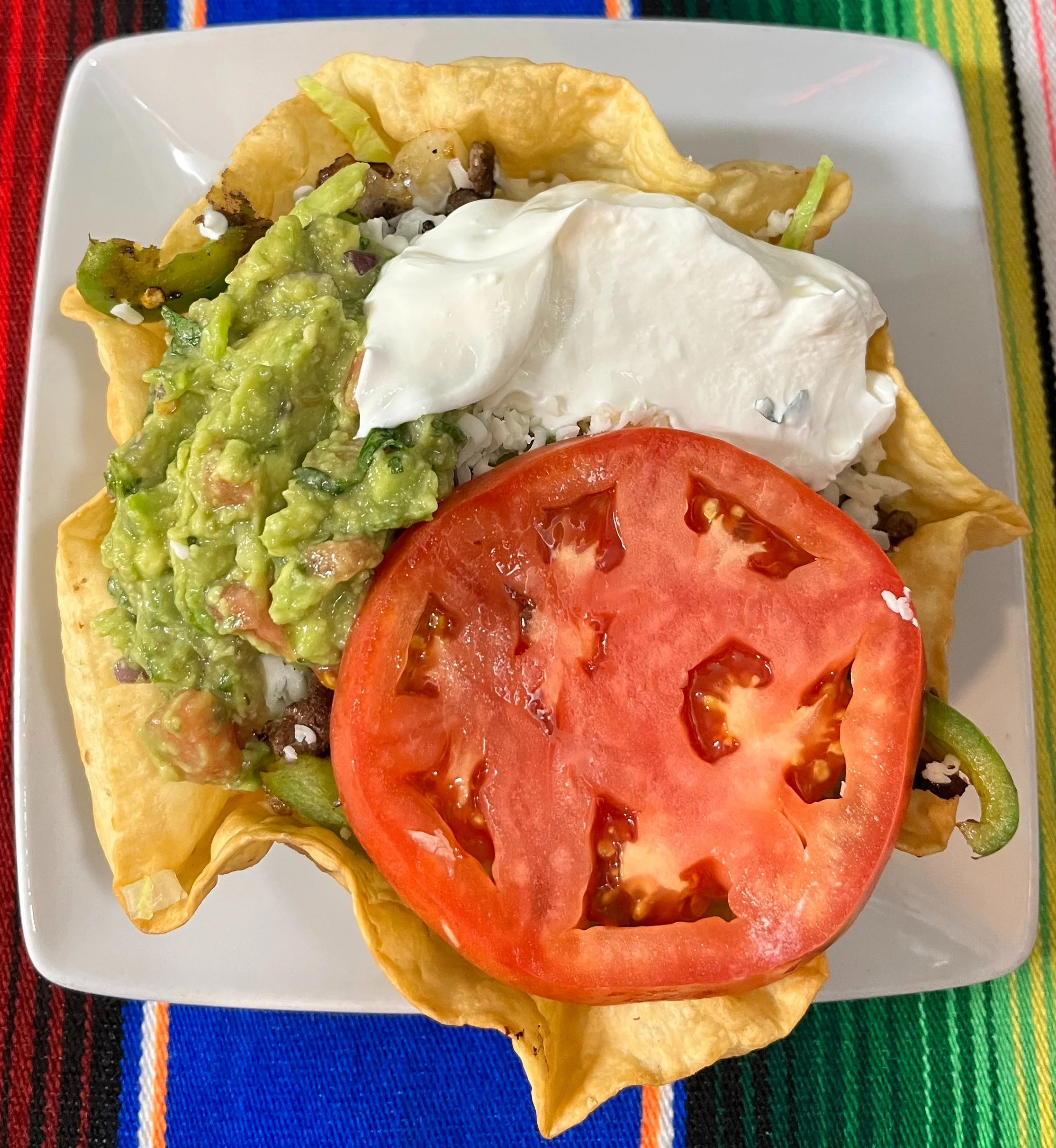 Colorful Mexican taco salad in a crispy tortilla bowl