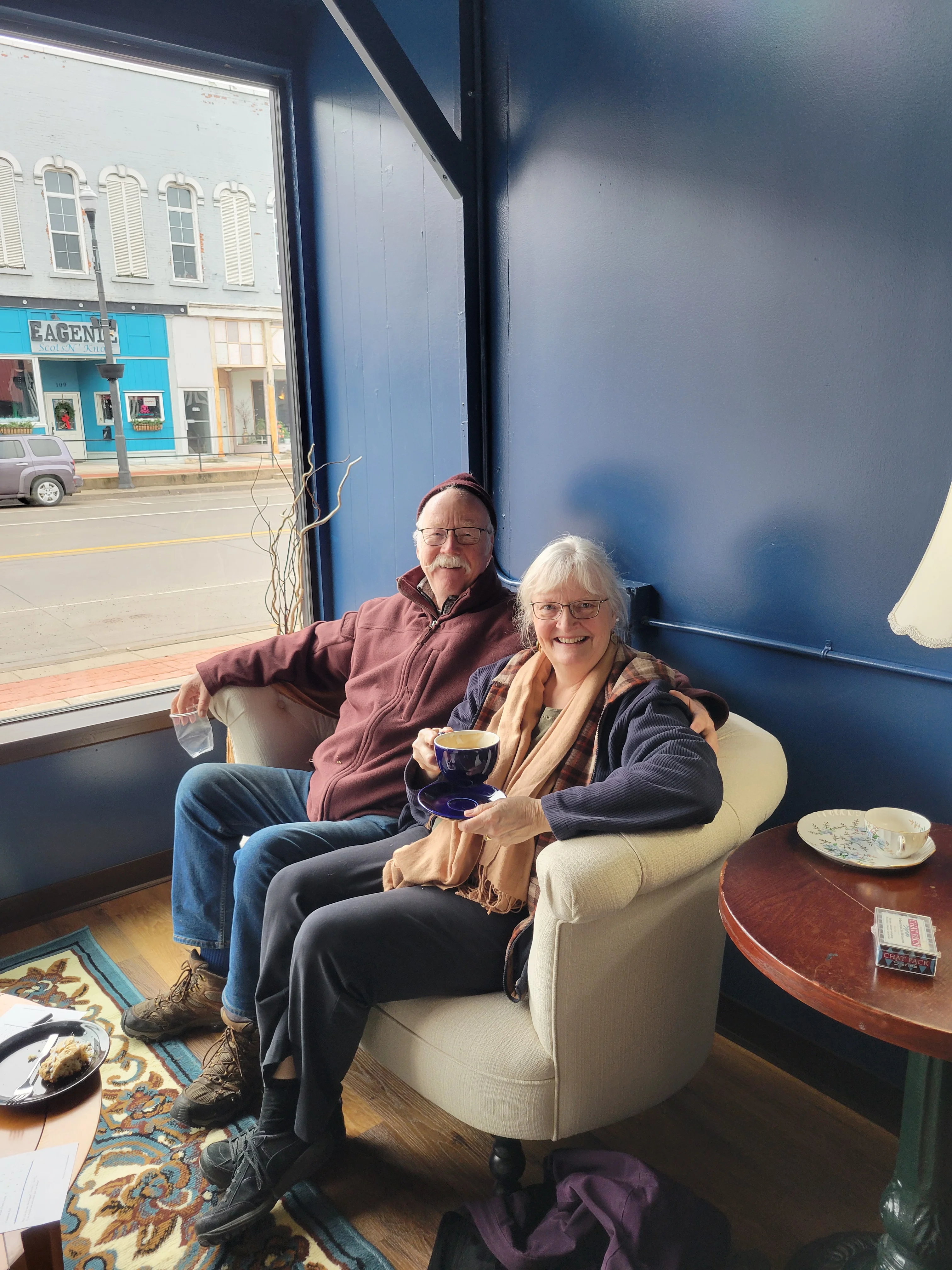 Cozy café scene with two guests enjoying coffee and dessert