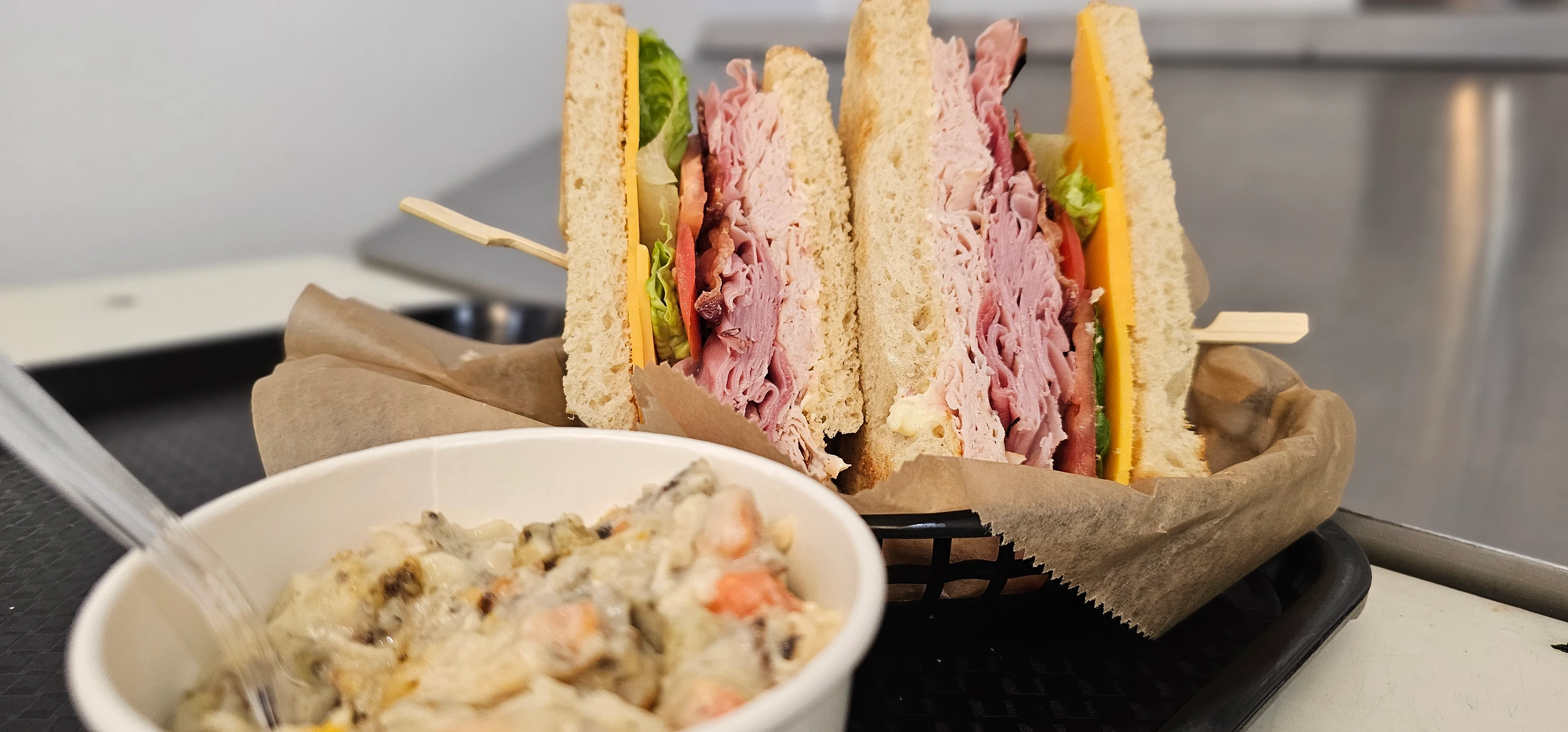 Classic deli sandwich with assorted meats and a side of creamy pasta salad