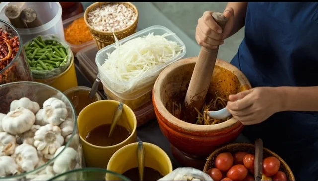 A chef preparing fresh ingredients for traditional Laos Thai cuisine