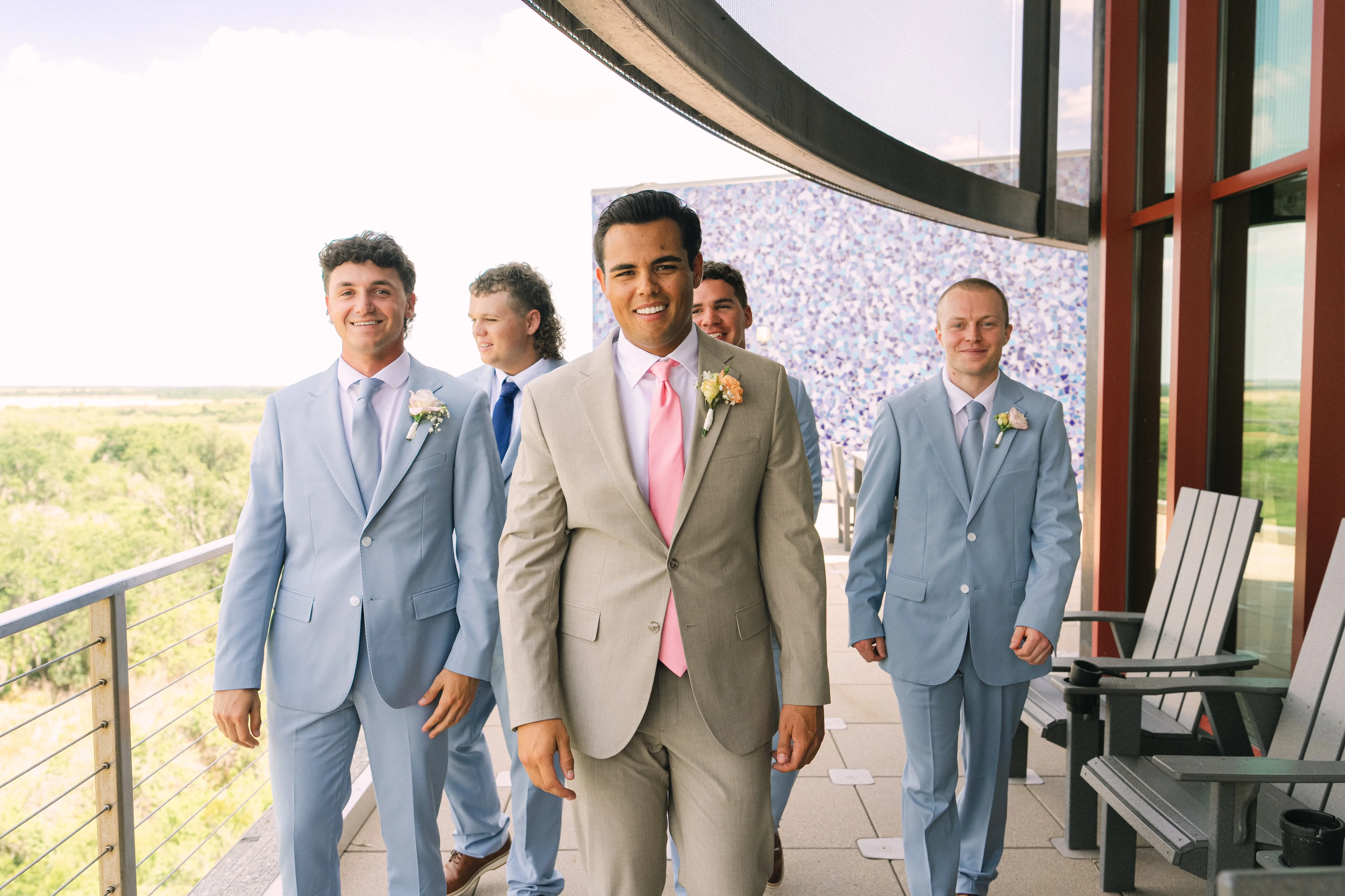 Groom and groomsmen in stylish suits at a wedding venue