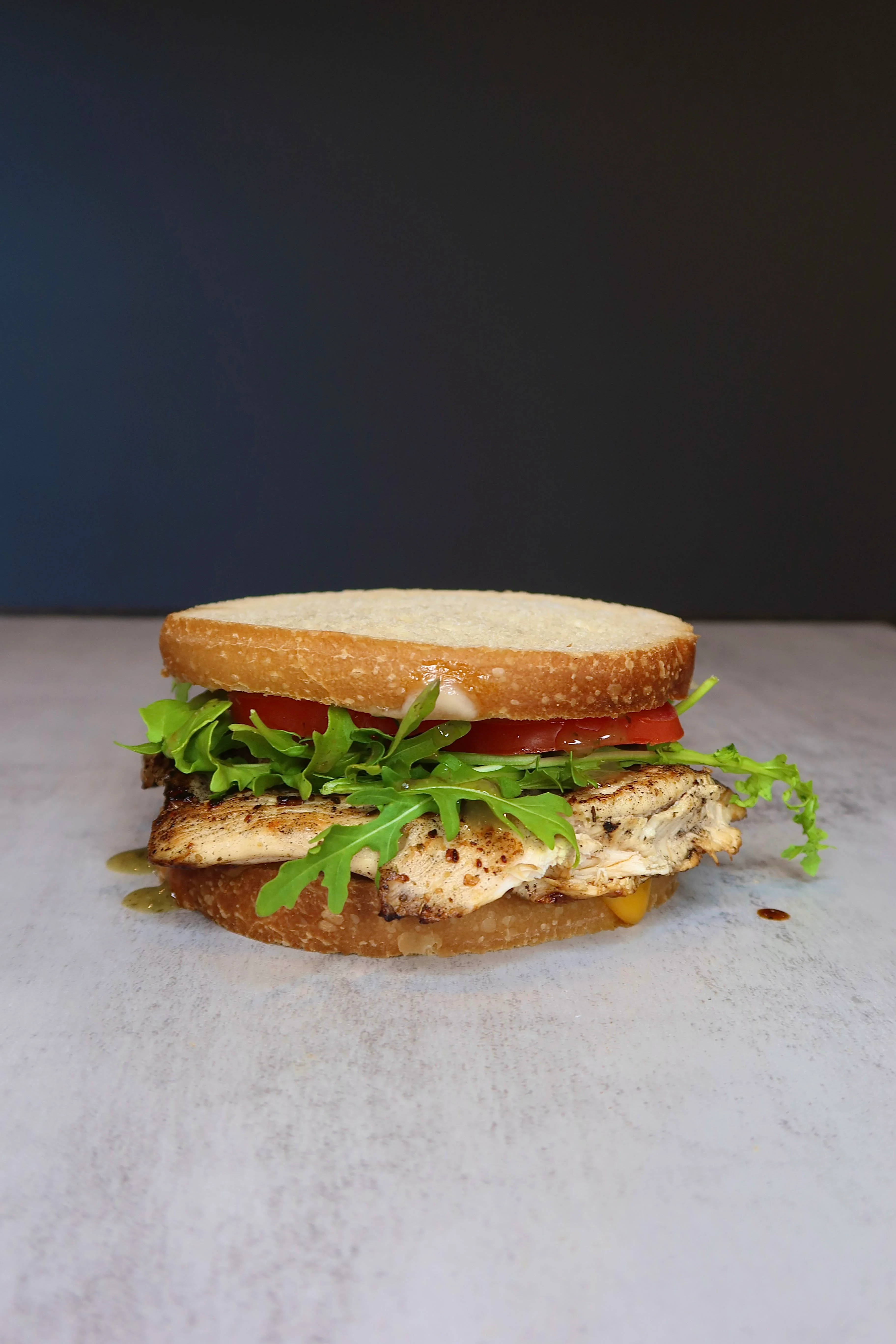 Grilled fish sandwich with fresh greens and tomato