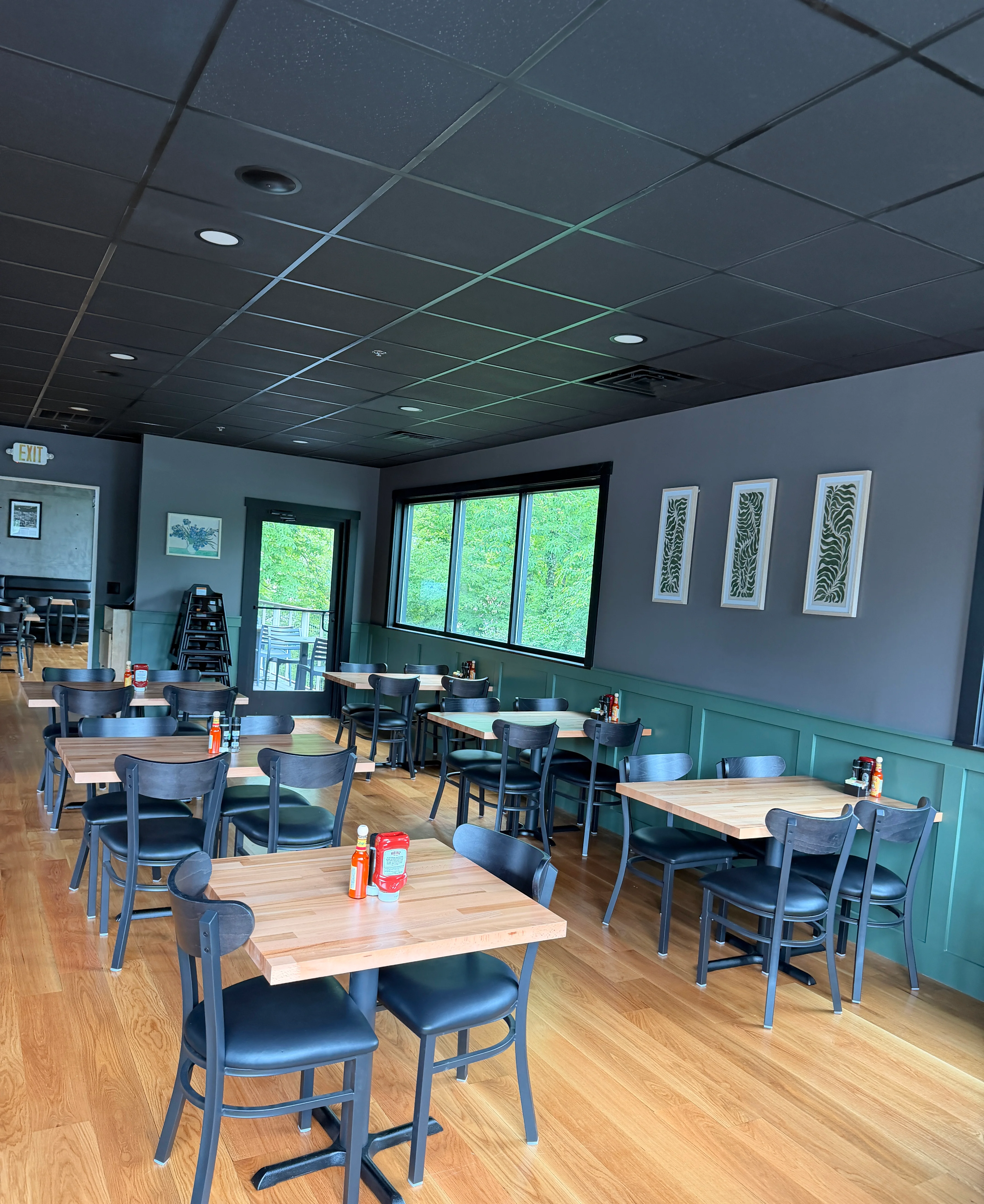 Modern restaurant interior with wooden tables and large windows